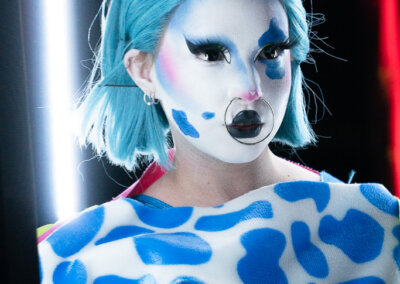 Artiste de Studio ZX aux cheveux bleus, maquillée et costumée comme aux cirques
